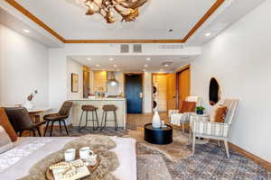 Living area featuring recessed lighting, crown molding, and a chandelier