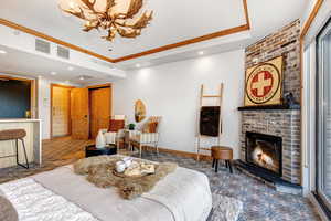 Bedroom featuring recessed lighting, a brick fireplace, a raised ceiling, and a chandelier