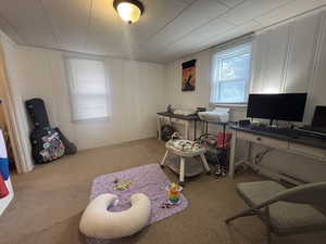 Carpeted office featuring a decorative wall