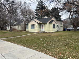 View of front facade with a front yard, a garage, and roof with shingles