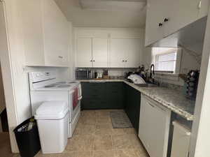 Kitchen featuring white cabinetry, white appliances, and light tile patterned floors