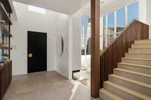 Entrance foyer with stairway and baseboards