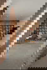 Living area with arched walkways, built in shelves, and concrete flooring