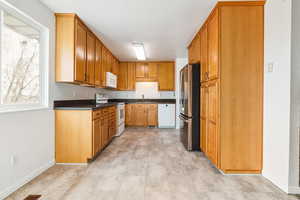 Kitchen featuring white appliances and brown cabinetry