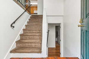 Stairs with a high ceiling and wood finished floors