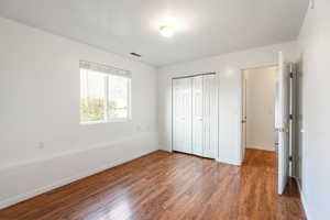 Unfurnished bedroom featuring wood finished floors and a closet