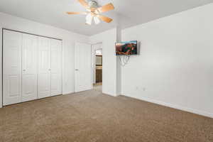 Unfurnished bedroom featuring a closet, carpet floors, and a ceiling fan