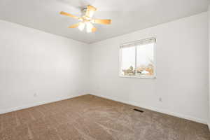 Unfurnished room featuring carpet and a ceiling fan