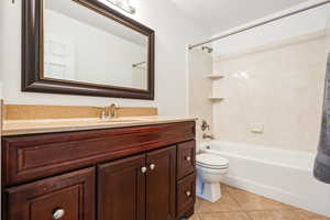 Full bathroom with shower / tub combo with curtain, vanity, and light tile patterned floors