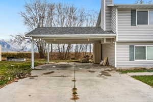 View of parking / parking lot with concrete driveway and a carport