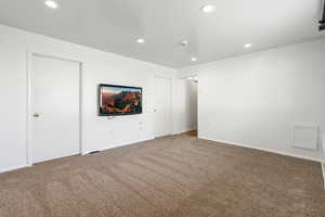Unfurnished living room featuring carpet floors and recessed lighting