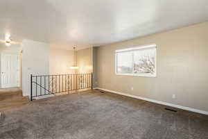 Unfurnished room with a chandelier and carpet floors