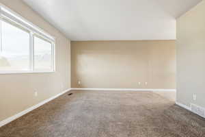 Spare room featuring carpet flooring and baseboards