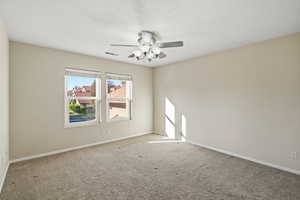 Carpeted empty room with a textured ceiling and ceiling fan