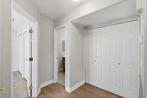 Unfurnished bedroom featuring light wood finished floors and a closet