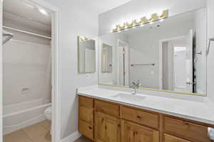 Bathroom with vanity, shower / tub combo with curtain, and light tile patterned floors