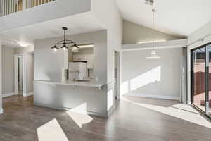 Kitchen with light countertops, white cabinets, a kitchen breakfast bar, freestanding refrigerator, and light wood-style floors