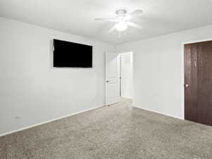 Unfurnished room with carpet floors, a textured ceiling, and a ceiling fan