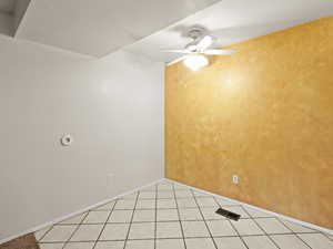 Spare room with light tile patterned flooring and a ceiling fan