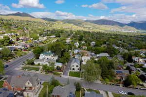 Aerial view of property and surrounding area with a mountainous background and nearby suburban area