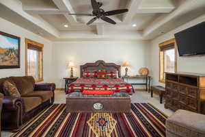 Carpeted bedroom featuring multiple windows, coffered ceiling, a ceiling fan, beamed ceiling, and recessed lighting