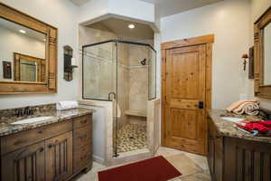 Bathroom featuring two vanities, a stall shower, recessed lighting, and light tile patterned floors
