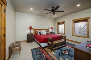 Bedroom with light carpet, ceiling fan, and recessed lighting