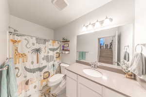 Full bathroom with curtained shower, vanity, and light marble finish floors