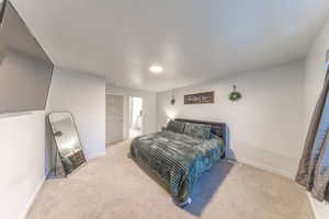 Bedroom featuring light colored carpet and ensuite bathroom