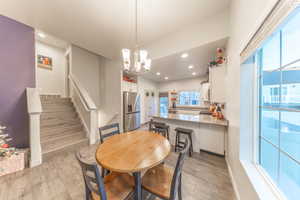 Dining space with stairway, recessed lighting, light wood finished floors, and a chandelier