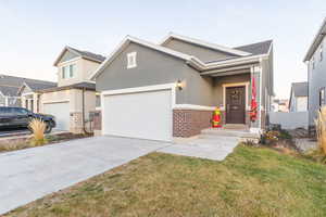View of front facade with stucco siding, driveway, and an attached garage