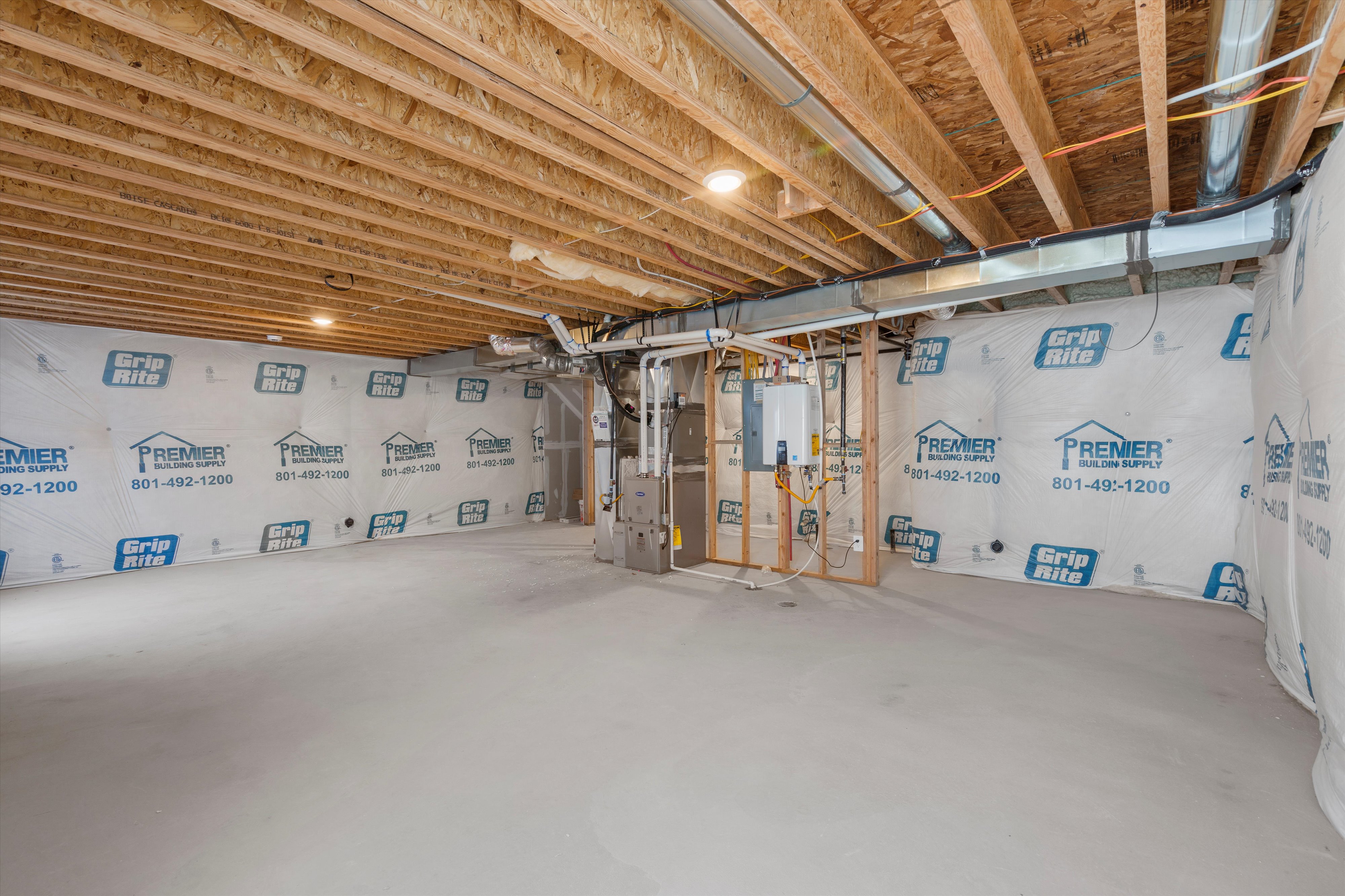 Unfinished basement featuring heating unit and water heater