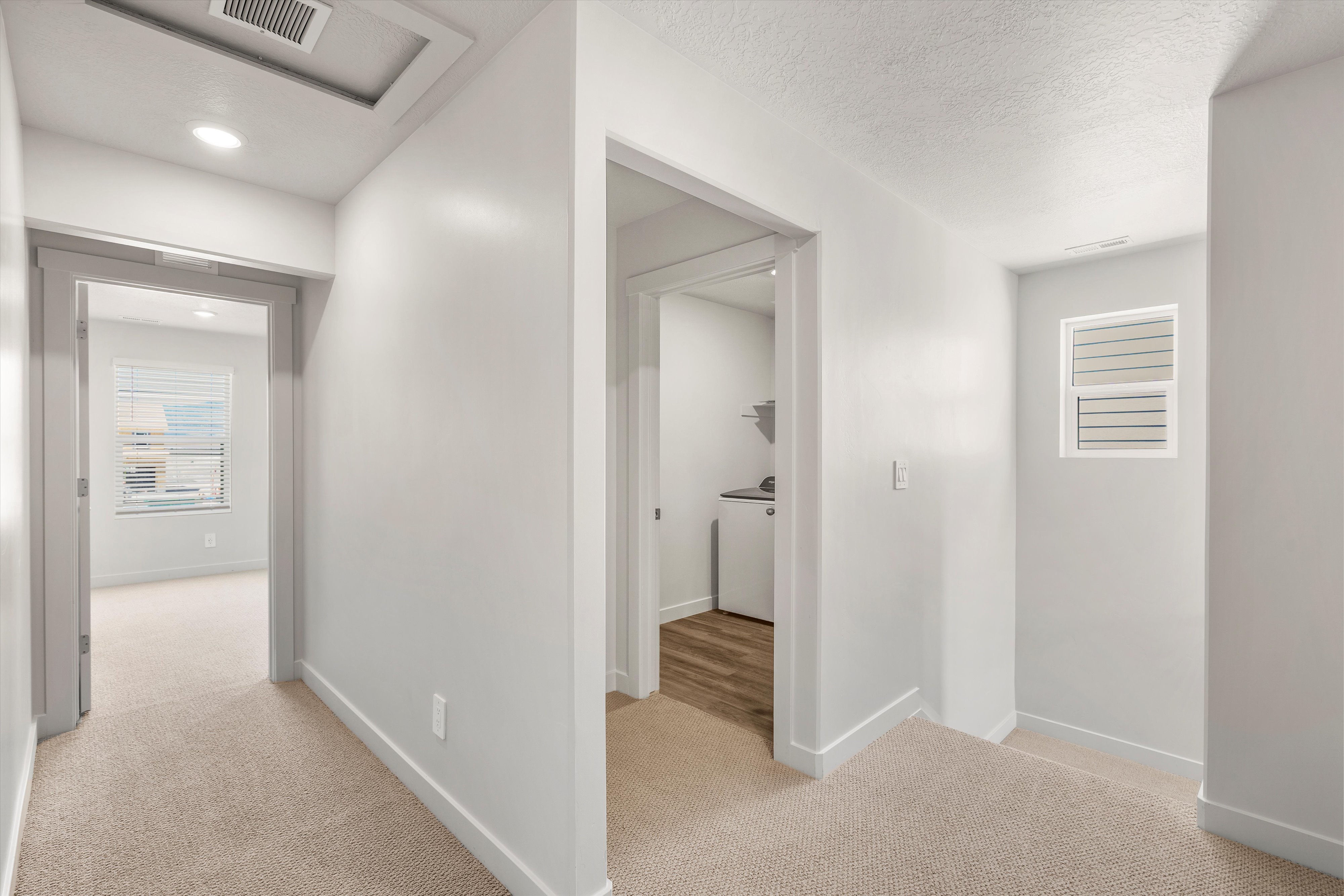**DISLCAIMER** Exterior & Interior packages may vary.Hallway featuring light colored carpet, a textured ceiling, and washer / dryer