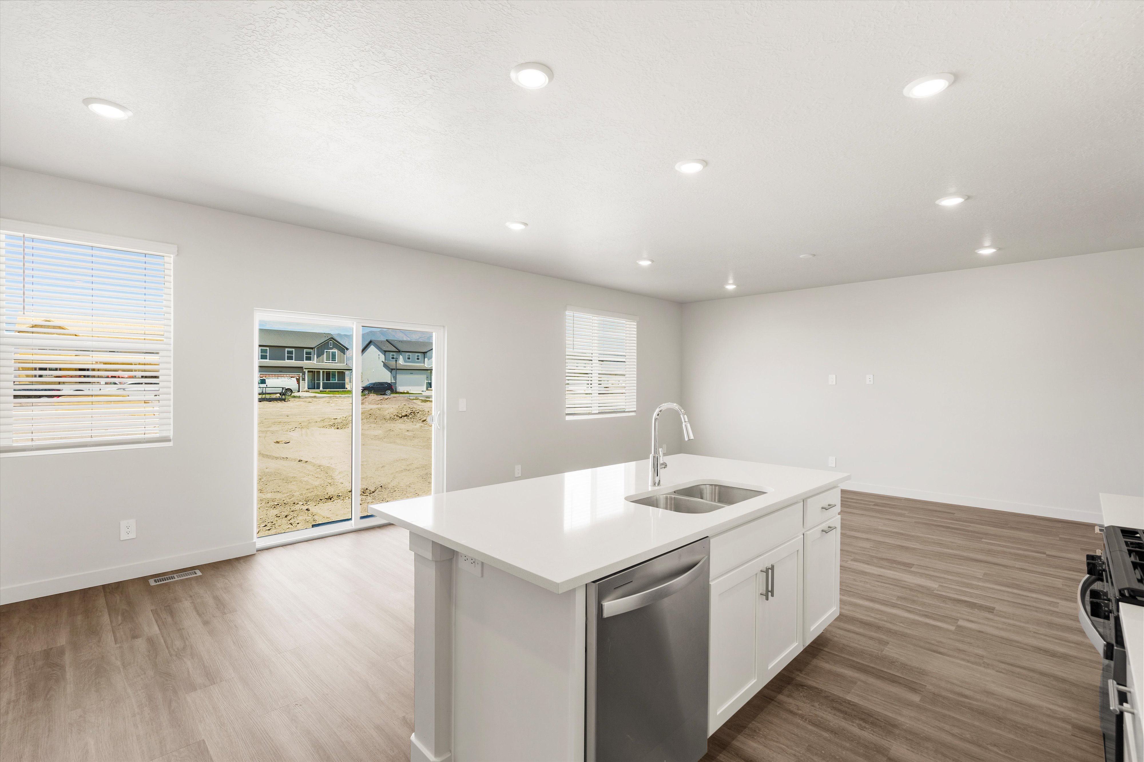 **DISLCAIMER** Exterior & Interior packages may vary.Kitchen featuring dishwasher, white cabinets, light wood finished floors, gas range oven, and recessed lighting