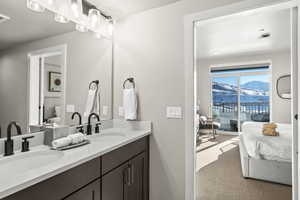 Ensuite bathroom featuring light carpet, double vanity, and a mountain view