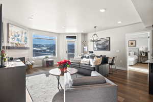 Living room with a tile fireplace, hardwood / wood-style flooring, recessed lighting, and a chandelier