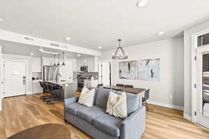 Living area featuring recessed lighting, light wood-type flooring, and a chandelier