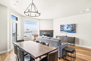 Dining space featuring a fireplace, a chandelier, light wood-type flooring, and recessed lighting