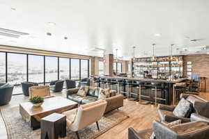 Living room with brick wall, light wood-style floors, and cooling unit