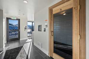 Interior space featuring a relaxing sauna, dark tile patterned flooring, a mountain view, and recessed lighting