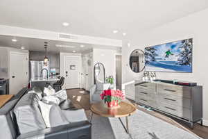 Living room with dark wood-style floors and recessed lighting