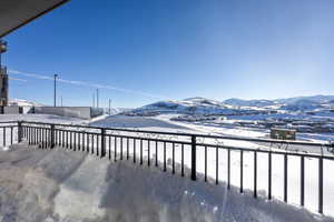 Snow covered back of property featuring a mountain view