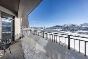 Snow covered back of property with a mountain view