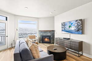 Living room with a tile fireplace and light wood-style flooring