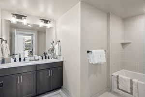 Bathroom with double vanity and tub / shower combination
