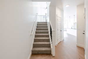 Stairway featuring wood finished floors and ceiling fan