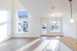 Unfurnished dining area with light wood finished floors and suspended lighting