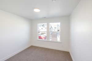 Carpeted spare room with baseboards