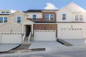 View of front of property featuring board and batten siding, driveway, and an attached garage