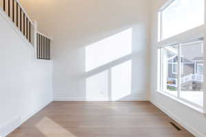 Unfurnished room with a high ceiling and light wood-style flooring